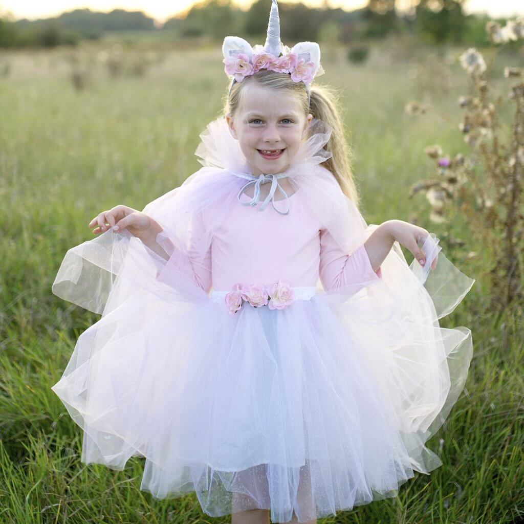 Girl wearing organza white tutu skirt with rose detail belt with pink leotard white organza cape and unicorn headband with matching flower detail