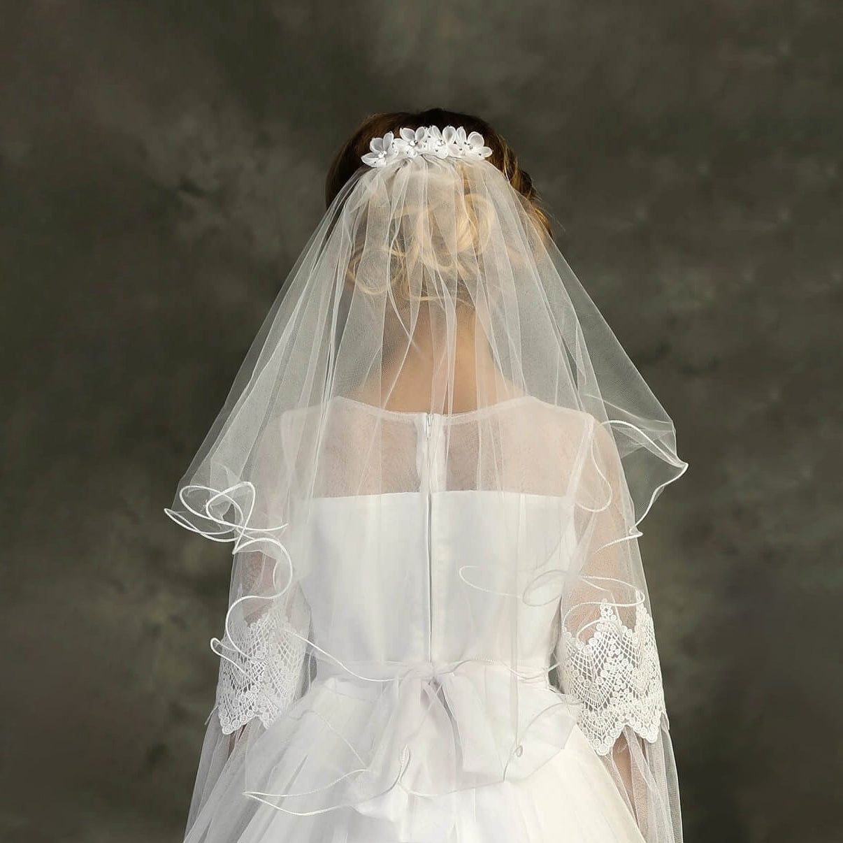 Girl's wearing white dress and flower comb with veil a